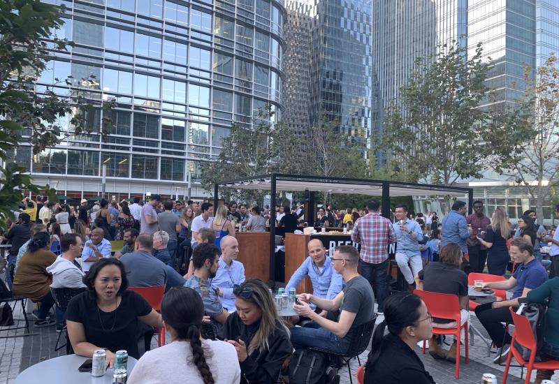 Large crowd of people sitting and standing in Main Plaza.