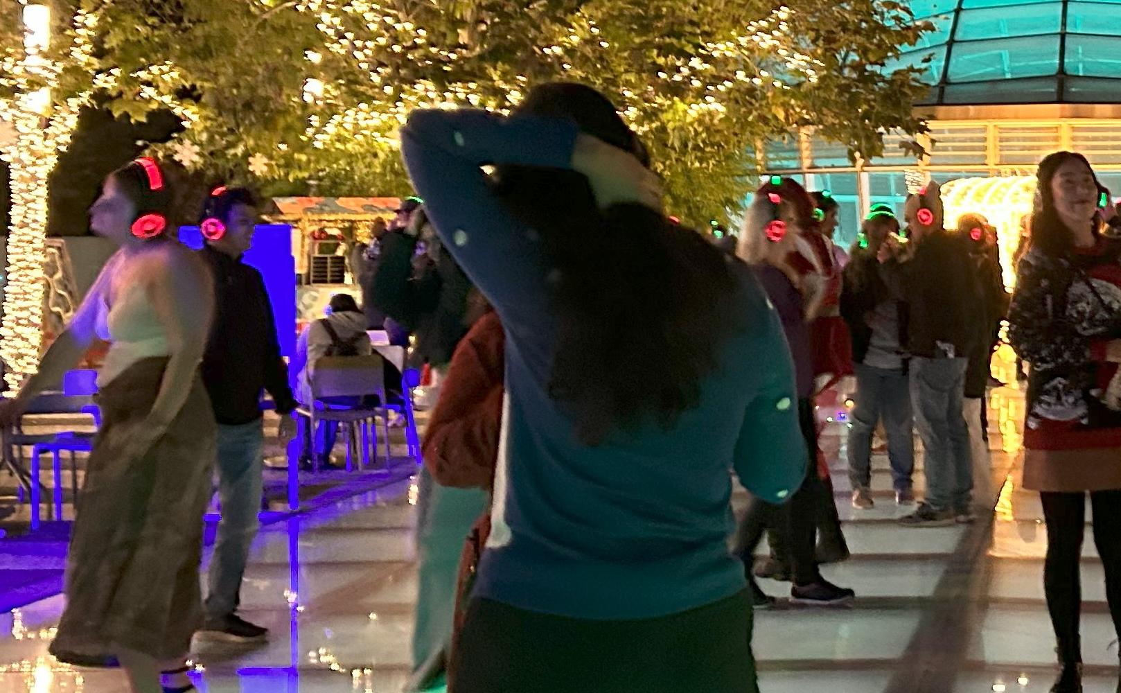 Group of people dancing at night in TJPA's Salesforce Park on the Main Plaza.