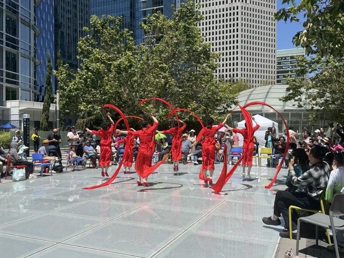 Red clothed dancers in the main plaza of Salesforce Park.